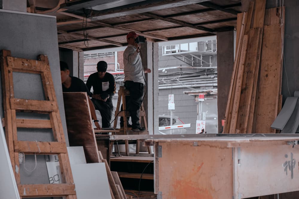 Gérant de PME du bâtiment sur un chantier, consultant ses factures sur tablette